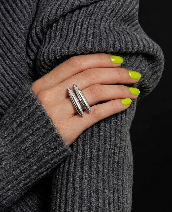 Maren silver double bar ring worn on index finger with acid green nails against grey knit jumper